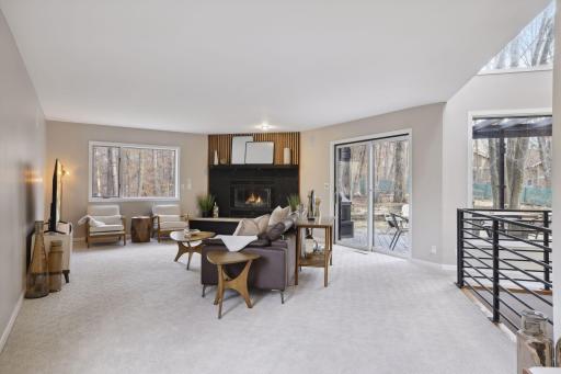East wing living room w/fireplace and walk out to deck/porch.