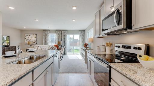 The kitchen looks out to the large deck located off the family room. Model picture shown. Colors and finishes may vary.