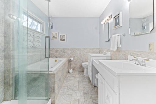 The primary bathroom features a jetted tub, shower, and dual sinks.