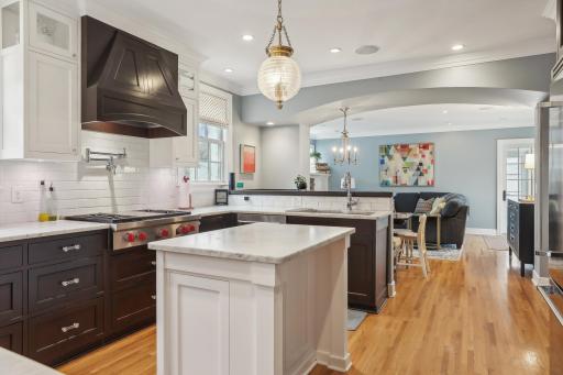 Chef's kitchen with center island, stainless steel appliance, abundant storage, opens to a cozy breakfast nook and family room.