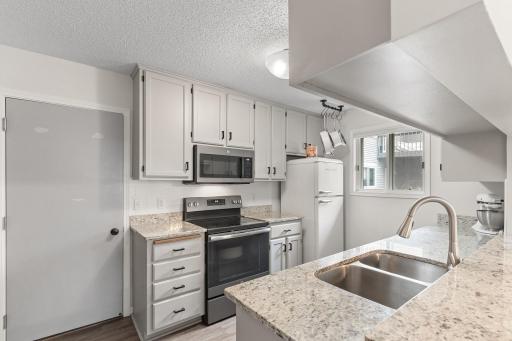 Well appointed kitchen with slate stainless steel appliances, granite counters, & subway tile backsplash. Please note new refrigerator has been installed since photo was taken.