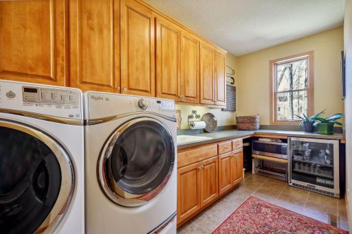 Incredible laundry room with sink, wine fridge, plenty of counter, front loading Whirlpool W/D and tons of cabinets!