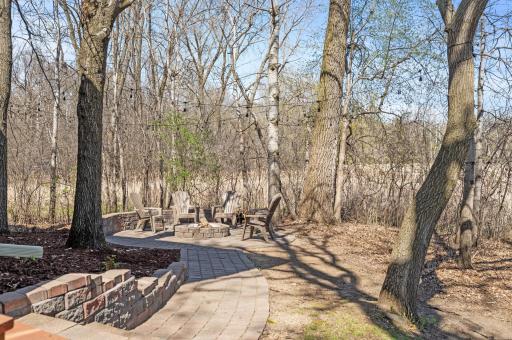 Paver walkway to the outdoor firepit nestled along side the home.
