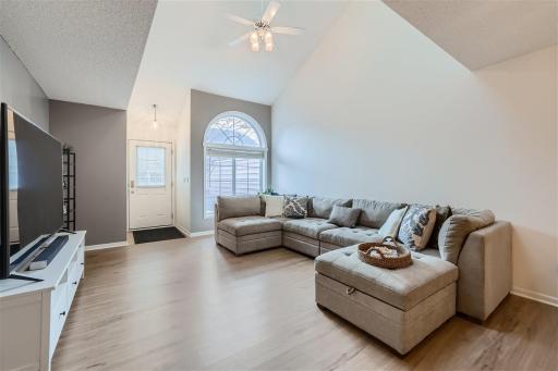 The living room is spacious and flooded with light from the high ceilings and the beautiful arched transom window