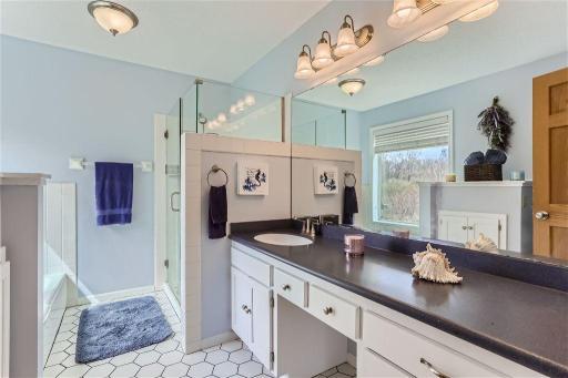The connected primary bathroom has been updated with a new countertop with plenty of counter space, faucet and shower doors! Simply beautiful!
