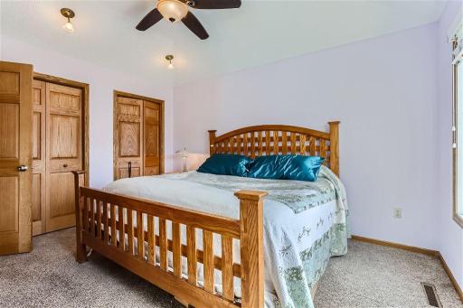 The primary bedroom in the upper level offers high ceilings, ample light and a beautiful modern ceiling fan. Plenty of closet space here as well and a connected bathroom.