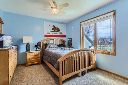 The 3rd upper level bedroom overlooks the side of the home and features a ceiling fan.