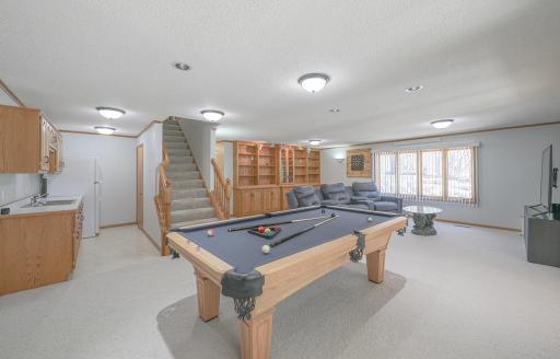 The regulation size pool table has recessed lighting placed above each pocket. The open floor plan keeps conversations flowing from the wet bar to the theater..jpg