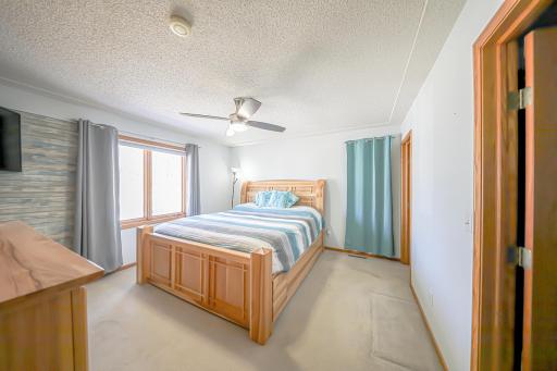 The primary bedroom has great airflow with open windows helped by the ceiling fan. A large three quarter bath and a huge walk in closet make for a peaceful haven away from the main communal spaces..jpg