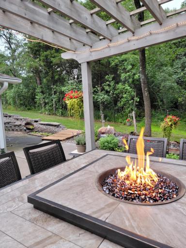 Twinkling lights accent the dancing fire for nights out under the pergola..jpg
