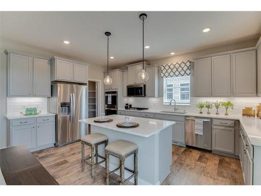 All of that beauty, yet function galore! Notice the space allowed throughout - plus an oversized pantry closet tucked back behind the refrigerator! A chef's dream!!! Photo of model home, color and options will vary.