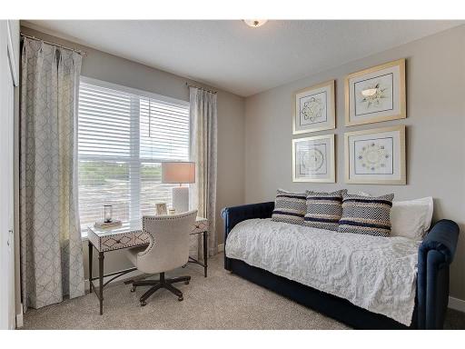 Tucked back off the mudroom, and away from the hustle and bustle of the main level living spaces, this bedroom resides adjacent to a 3/4 bath and serves as the perfect guest room or your home office! Photo of model home, color and options will vary.