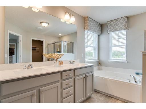 The Primary Suite bathroom, featuring both the extra deep soaking tub and oversized stand-in shower! Not to be outdone by not one but TWO spacious walk-in closets!! Photo of model home, color and options will vary.