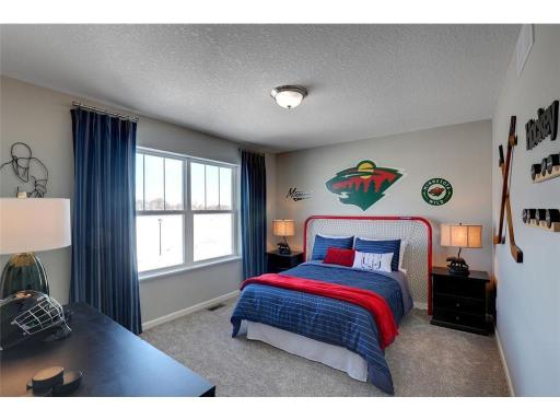 Each of the home's secondary bedrooms on the upper level come nicely sized and all feature their own private walk-in closet. Photo of model home, color and options will vary.