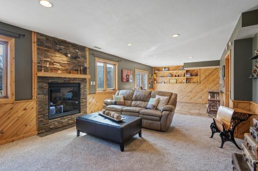 Lower level family room with stone surround gas fireplace