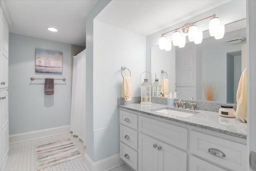 Lower-level guest full bathroom. In- floor heating and granite countertops.