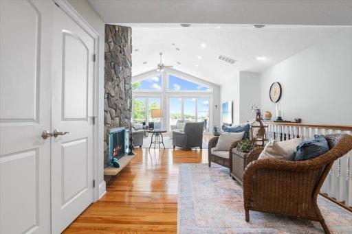 Amazing foyer area that opens up to seating around the fireplace. Open concept living area with expansive windows, vaulted ceilings, and walkout to the deck. There is so much natural light in this space.