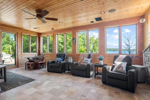 Large four-season porch with a walk out to one of the patios. After spending time out on the lake, come inside and relax around the fireplace in the four-season porch.