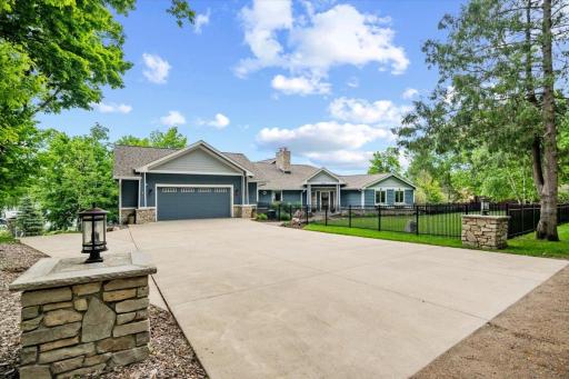 Enter through the stone light pillars to 8346 Irvine Ave NW. Metal fencing in the front yard with two entry/exit gates. Oversized two stall heated garage with epoxy flooring.