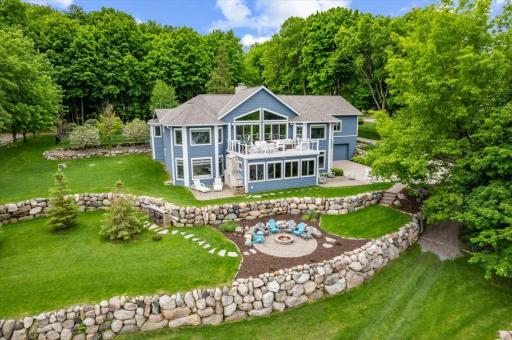 Plenty of boulder firepit seating to enjoy time around a summer fire and view Cedar Lake at sunset. Tall mature trees outline the property providing a private lake living experience.