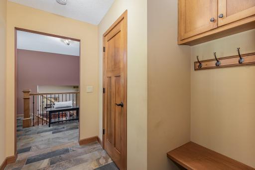 This mudroom (just off of the garage entrance & front foyer) also has slate tile floors, a convenient seat bench, coat closet & hooks, and additional overhead storage cabinets.