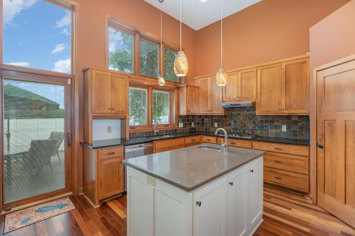 This view shows the door for the walk-in pantry (on the far right); the stainless steel exhaust fan/hood, & 5 burner, Kenmore Elite gas cooktop. Note: all of the counter space on either side of the cooktop as well.