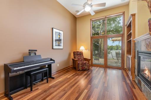 The sitting room features: a 12 ft knock down ceiling w/1 recessed light, a ceiling fan & 5 speaker rough-ins; and Brazilian cherry hardwood floors. The recliner and piano are available for purchase.