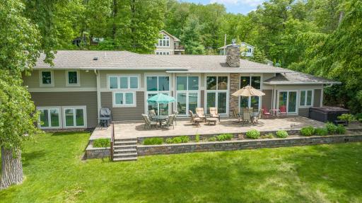 Welcome to 13140 Panorama Ave N in Stillwater. This exquisite home is nestled on the shores of Big Carnelian Lake. This 60' patio includes: a brand new Weber grill, a hot tub (new in 2020), 2 outdoor speakers, and ALL of the furniture shown here.