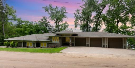 A twilight view of the front of the home. It has an oversized, 3 car garage with: separate, insulated garage doors, and 3 garage door openers.
