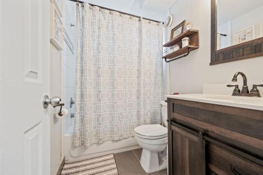 Updated lower level full bath features tiled floors and shower surround and newer vanity.
