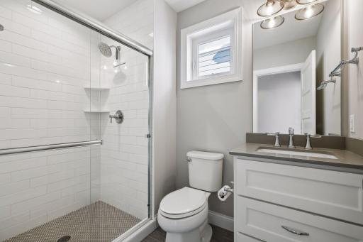 Adjacent to the Junior Bedroom you will find a Â¾ Bathroom with a comfort-height vanity and subway tiled shower with a penny tile floor.