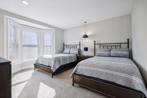 This spacious bedroom features a south-facing bay window and offers room for two full-size beds.