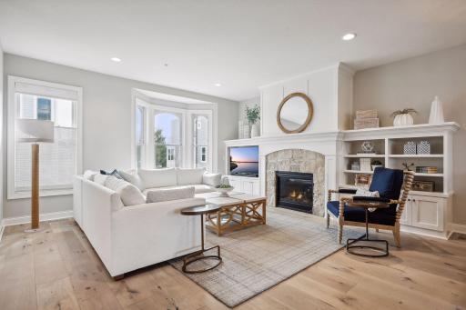 The Family Room enjoys an inviting gas fireplace with stone surround that is flanked by custom built-in cabinetry and bookcases.