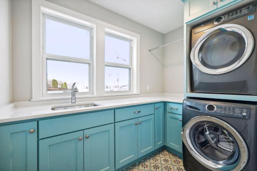 Thoughtfully located on the upper level, the Laundry Room offers cabinetry with quartz countertops and a stacking washer and dryer duo from Electrolux.