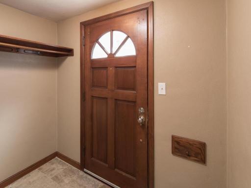 Front entry with ceramic tile floors, space to hang coats, and mail slot.