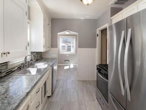 Updated kitchen features ceramic tile floors, new countertops, backsplash and stainless steel appliances.