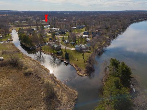 Looking back towards the property from where the channel meets the lake. Property location marked by red arrow.
