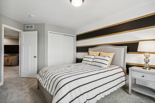 (Photo of decorated model, actual home's finishes vary) The second generously sized upper level secondary bedroom with a spacious closet.