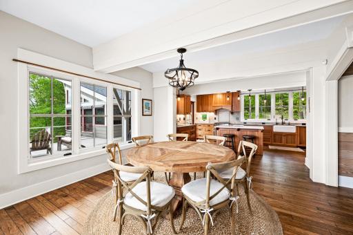 Dining Room features ceiling beams and large windows with views of woods and lake