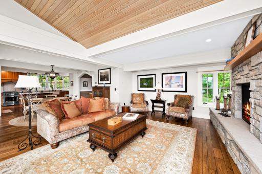 Pickle wood sloped ceiling and walls toward large windows, ceiling beams and recessed ceiling lights