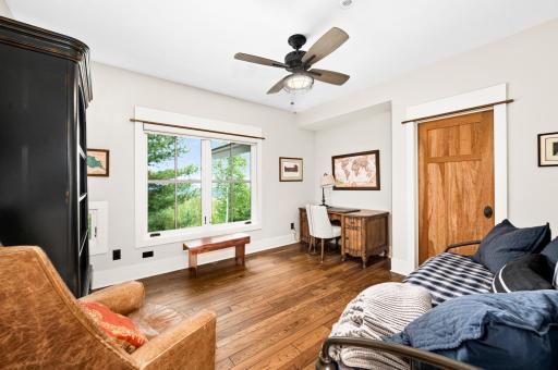 Main Level: Bedroom/Office includes a walk-in closet, large windows with views of lake, fan with light, crafted in-set for desk and cute interior window into Foyer