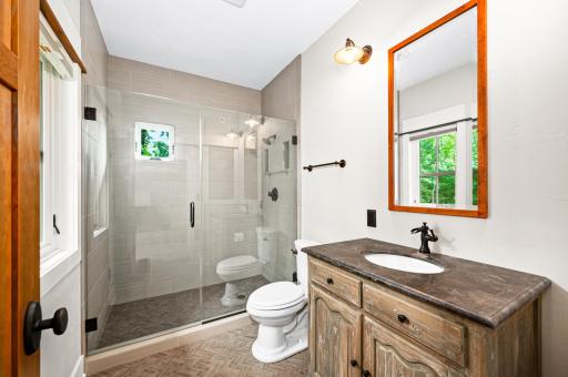 Main Level: 3/4 Bath includes large shower, unique tile work, large hand-built medicine cabinet, classy furniture-like vanity
