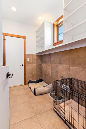 Indoor kennel with heated floors, tiled walls, shelving and dutch door so you can see them.