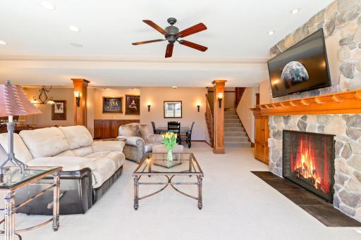 Heated floors, custom built-in, gas burning stone fireplace with patio door to pool area