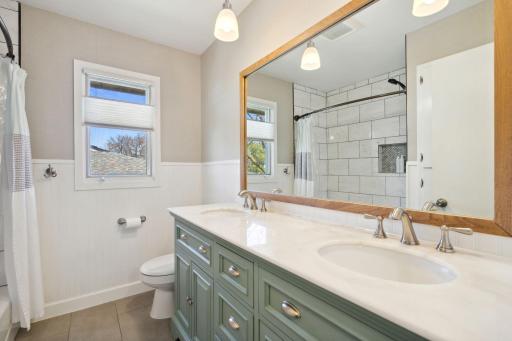 Renovated main level bath is complemented by a fully tiled shower.