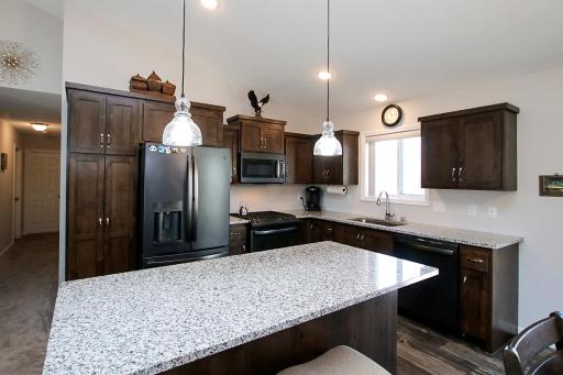 Warm cabinetry, granite counters and stainless steel appliances
