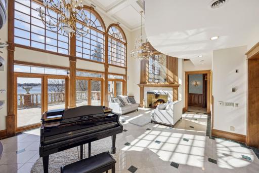 Two story great room with panoramic windows, fireplace, and stunning chandeliers.