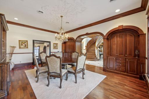 Formal dining room with built-in cabinets and elaborate ceiling artwork.