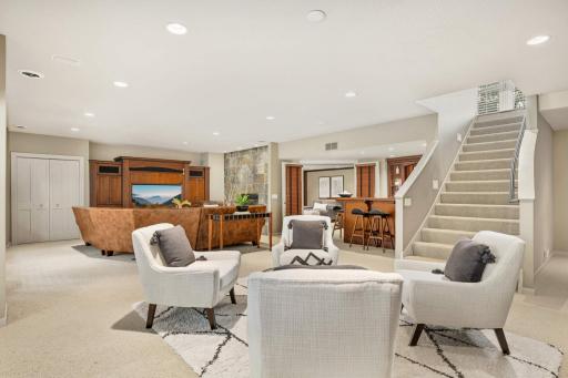 Spacious staircase leads to walkout family room with high ceilings, custom Cherry cabinetry and built-ins!