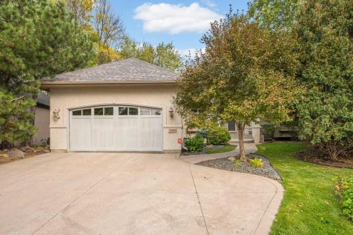 Custom Cedar garage door with oversized stamped concrete drive.
